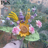 Ramillete de flores de ganchillo hecho a mano con flores amarillas y moradas sobre hojas verdes