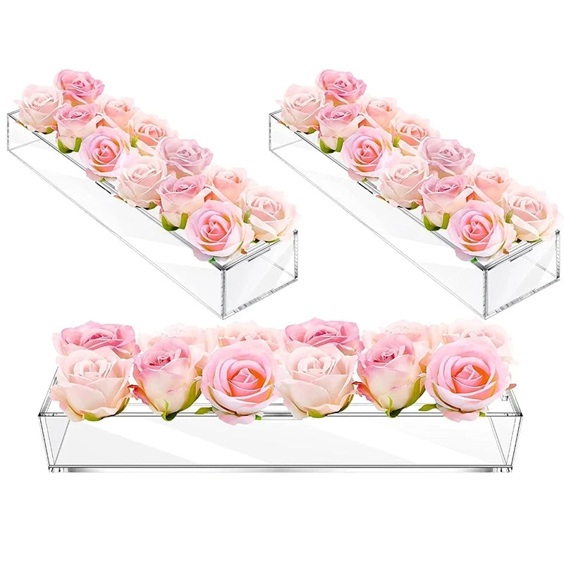 Clear acrylic rectangular vase displaying pink roses arranged in multiple tiers