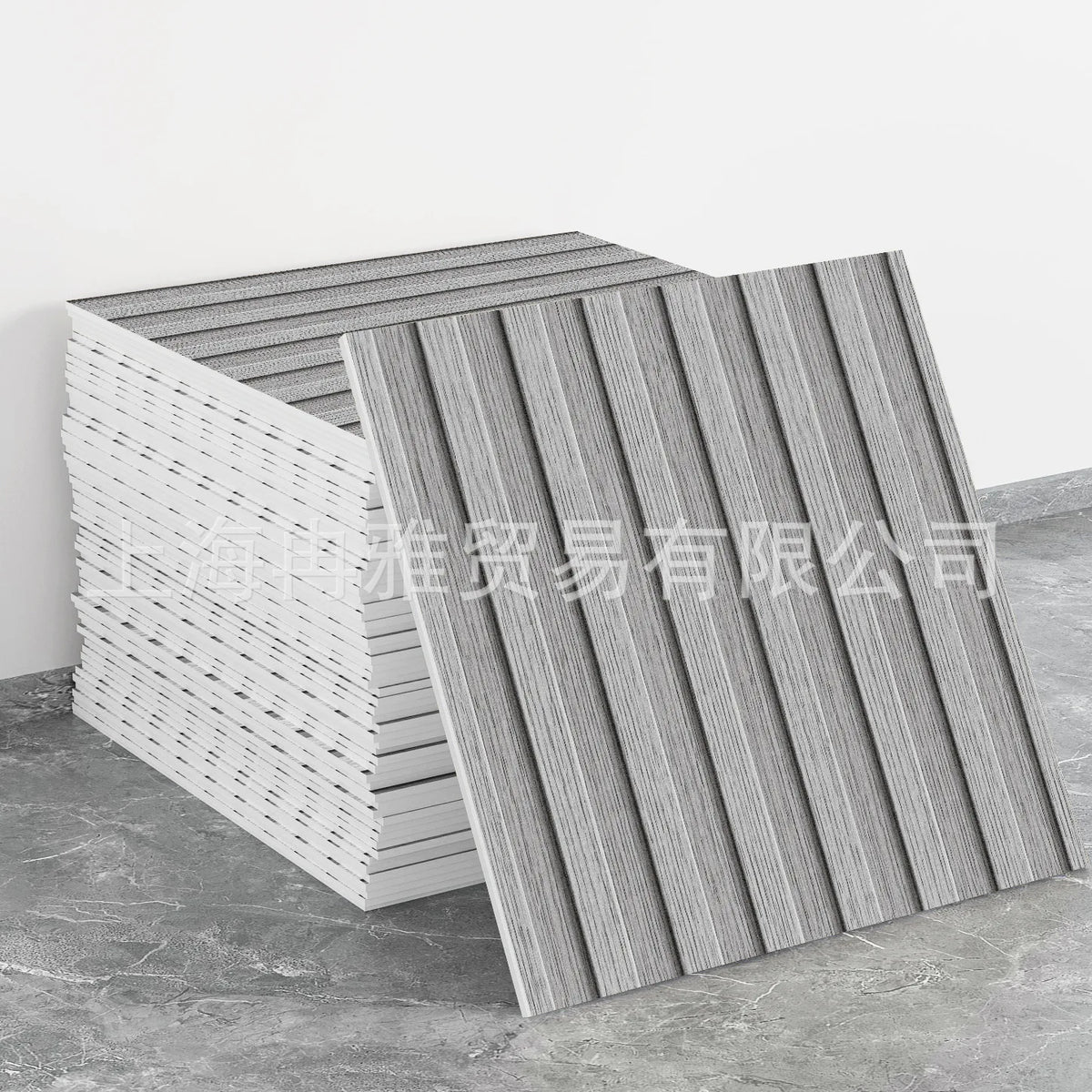 A stack of gray and white marble peel-and-stick tile stickers with gold accents displayed on a concrete surface.
