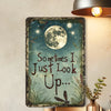 Vintage metal wall decor featuring a quote 'Sometimes I Just Look Up' with a moon and dragonflies on a teal background.