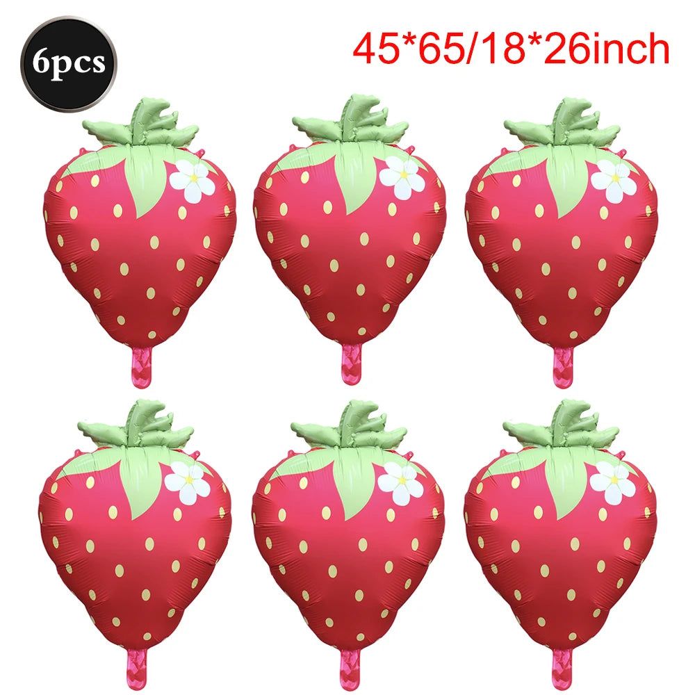 Six pink strawberry foil balloons with green leaves and white dots for party decorations
