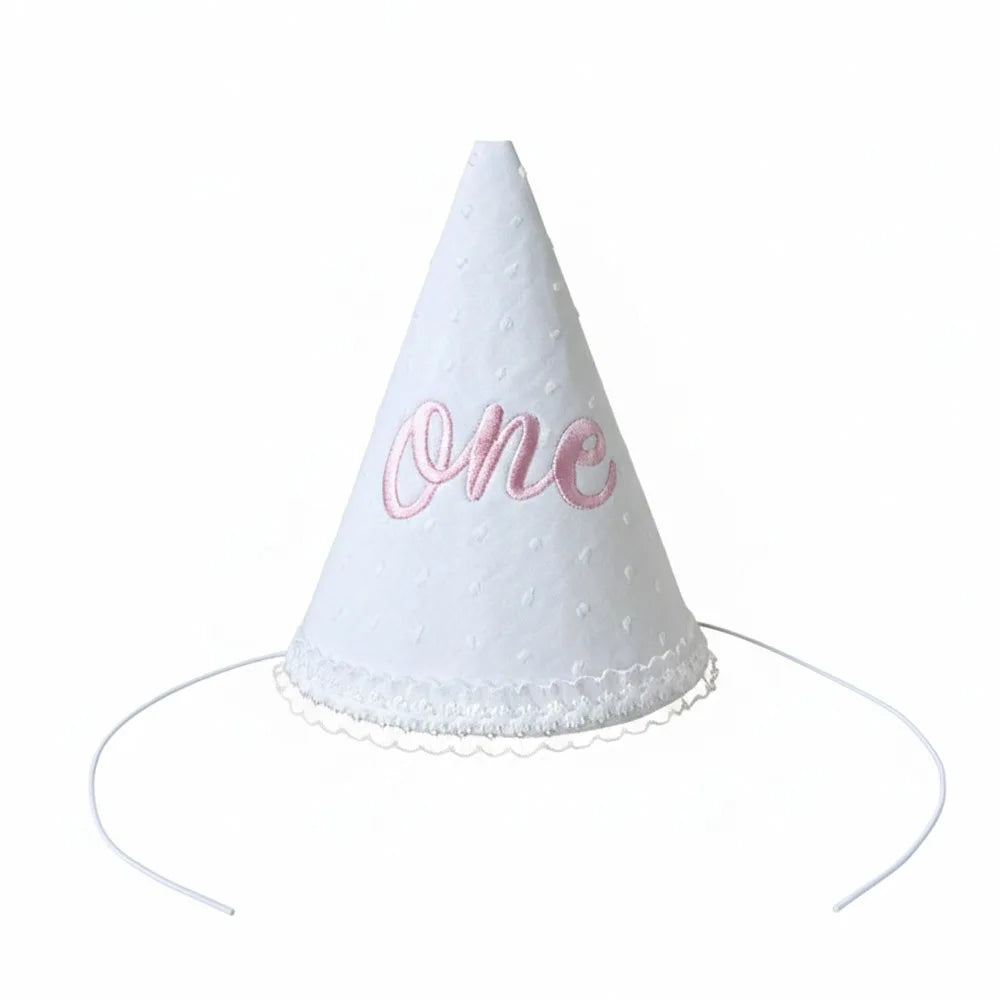 White conical party hat with the word one written in pink glitter