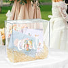 A clear acrylic gift box filled with handmade cards and natural straw decor on a white table.