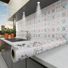 A kitchen countertop features a roll of waterproof oil-proof wall sticker with floral patterns mounted on a tiled backsplash.