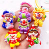 A collection of colorful resin clown charms for DIY crafts and scrapbooking displayed in a hand.