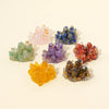 A collection of colorful natural crystal stone clusters in pink, blue, purple, and orange hues.