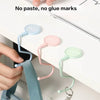 Close-up of silicone purse and bag hooks in various pastel colors attached to a white surface.
