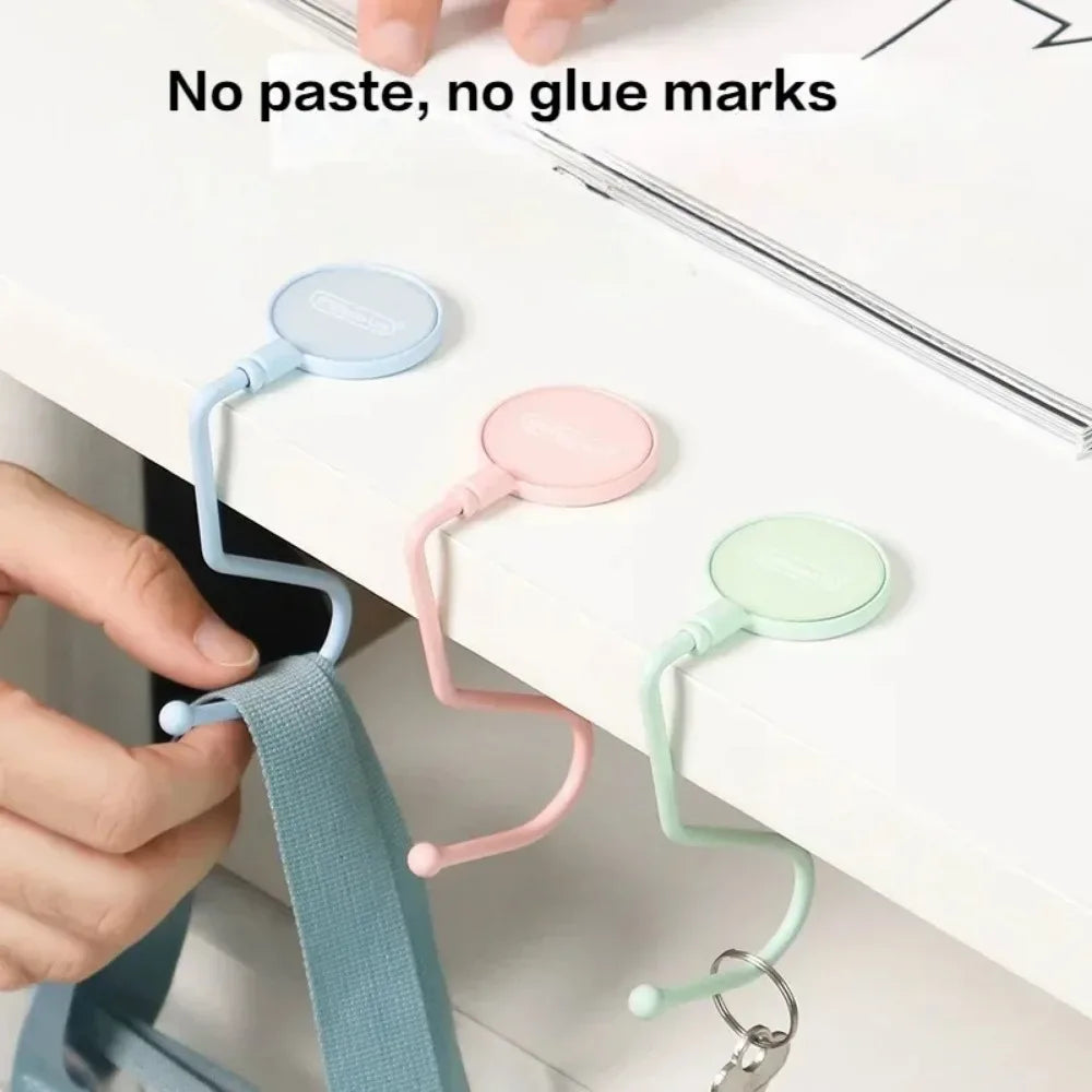 Close-up of silicone purse and bag hooks in various pastel colors attached to a white surface.