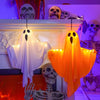 An orange LED ghost hanging decoration light displayed on a white fireplace mantel with skulls and skeletal props.
