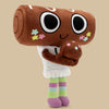 A brown plush toy resembling a rolling pin with large black eyes and small star embellishments, holding a smaller brown plush