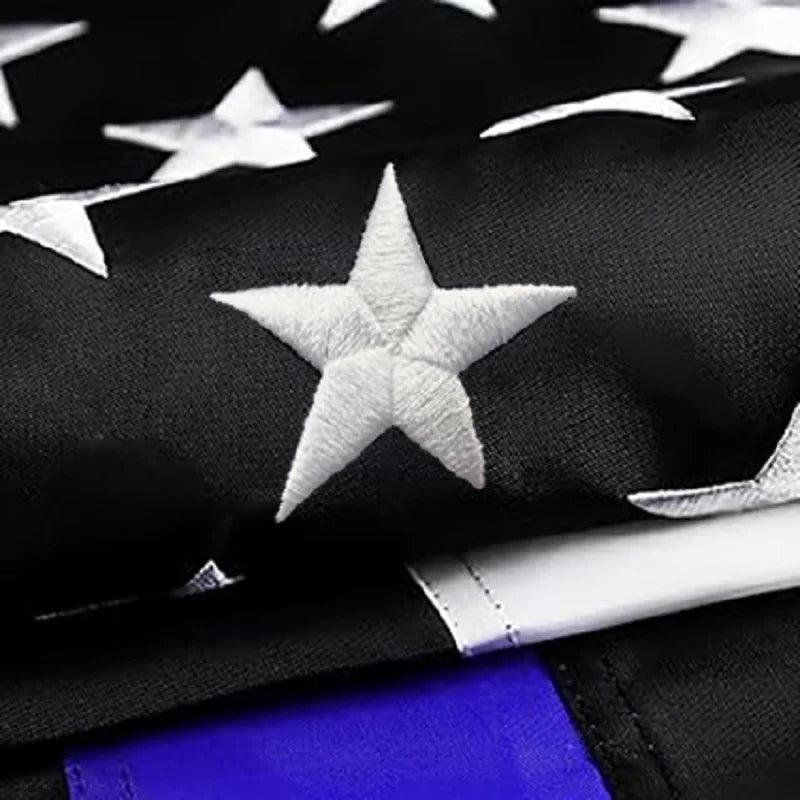 Close-up of a black fabric featuring embroidered white stars on a flag design.