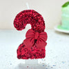 A large number 9 made of red glittery cake pop decorations with a matching red bow, displayed on a white stand.