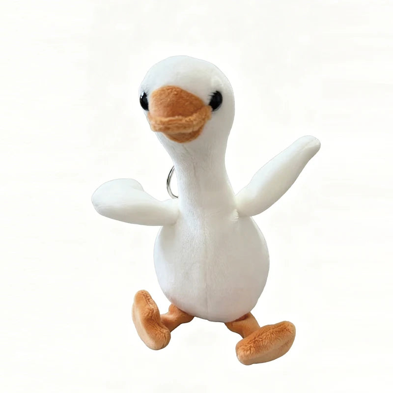 A white duck plush toy with orange feet and a beak, used as a keychain pendant.