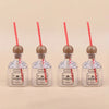Four clear plastic drinking bottles with wooden stoppers and red straws, labeled Patron tequila.