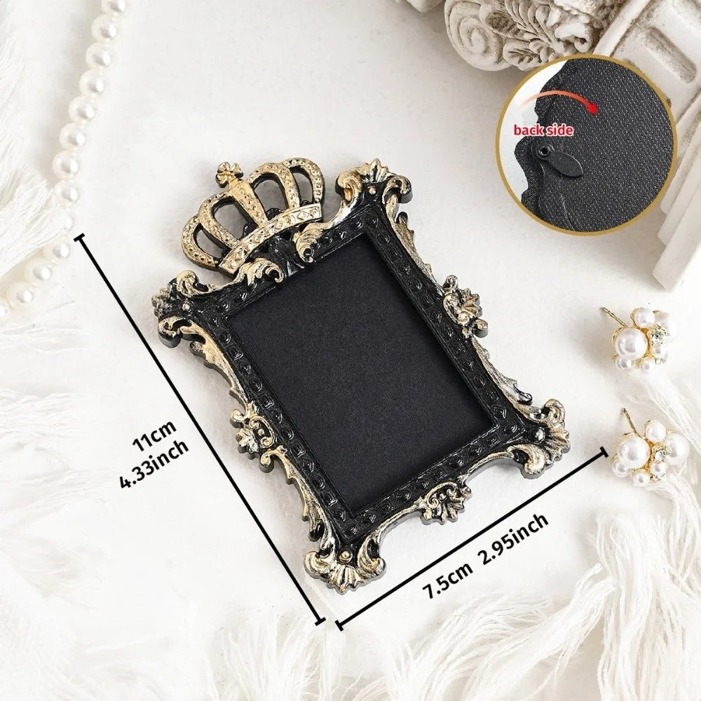 A vintage baroque resin hanging photo frame with an ornate gold crown detail displayed on a white surface.