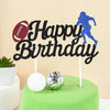 Black birthday cake toppers featuring a soccer player silhouette and a football on a green cake.