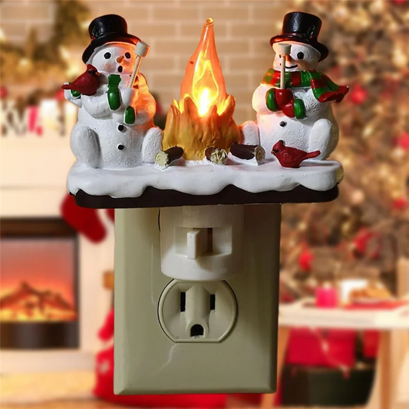 A decoration featuring two snowmen with a campfire light on top, mounted on a wall outlet.