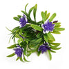 A cluster of artificial purple and white lotus flowers on green foliage.