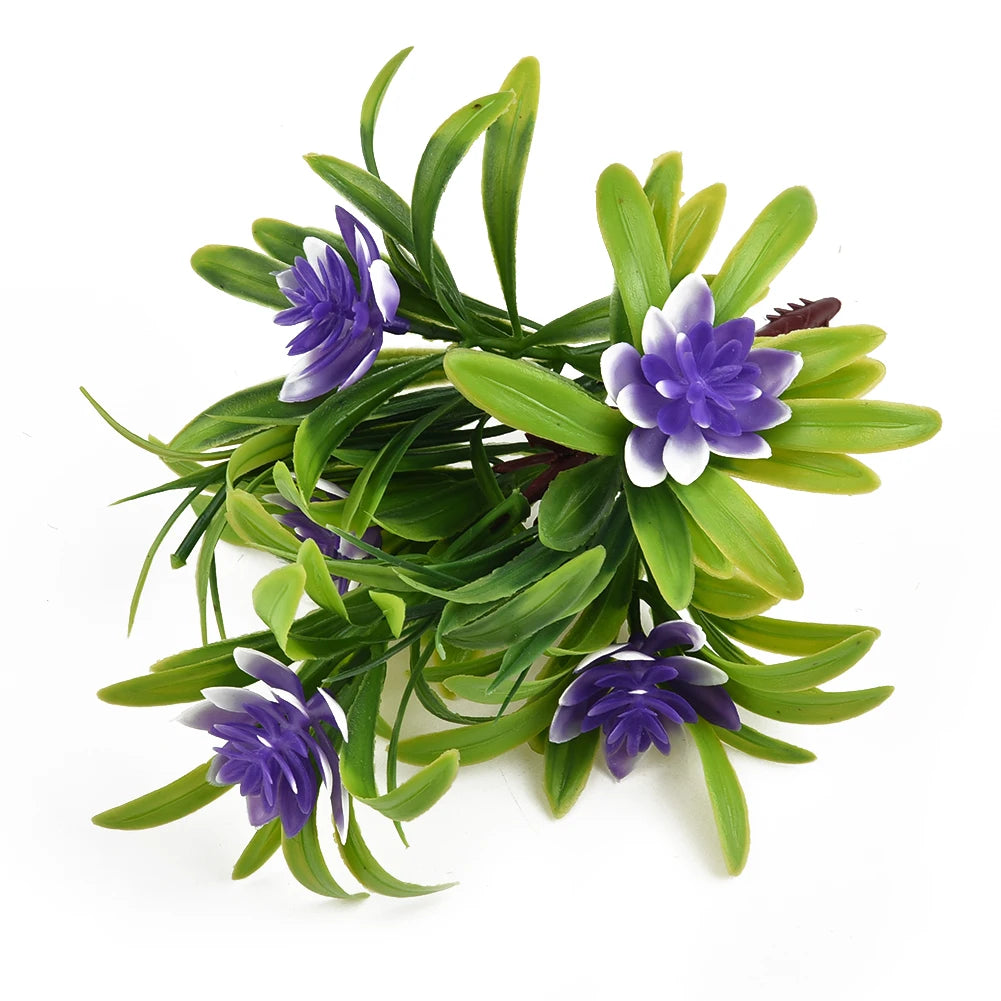 A cluster of artificial purple and white lotus flowers on green foliage.