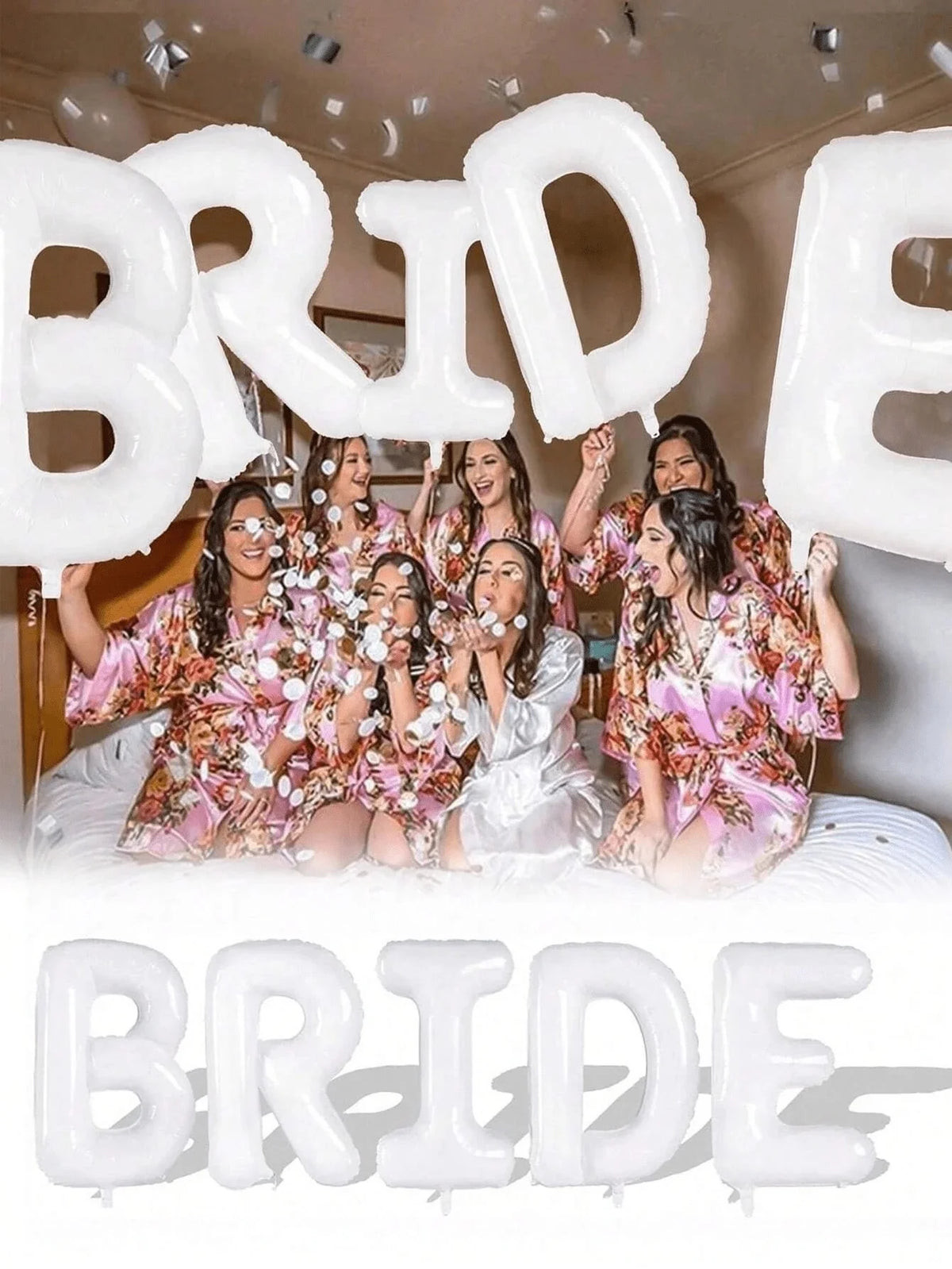 A group of women posing with large white letter foil balloons spelling the word BRIDE