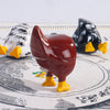 A set of three playful chicken butt fridge magnets in white, red, and black against a patterned cloth.
