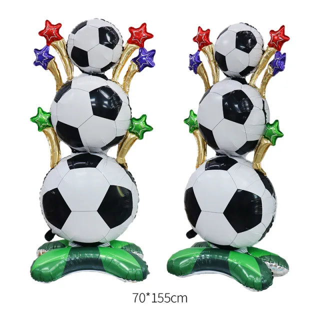 A standing foil trophy balloon featuring soccer balls and gold accents with red and blue star decorations.