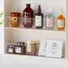 A display of various skincare products including bottles and jars on a clear acrylic shelf divider.