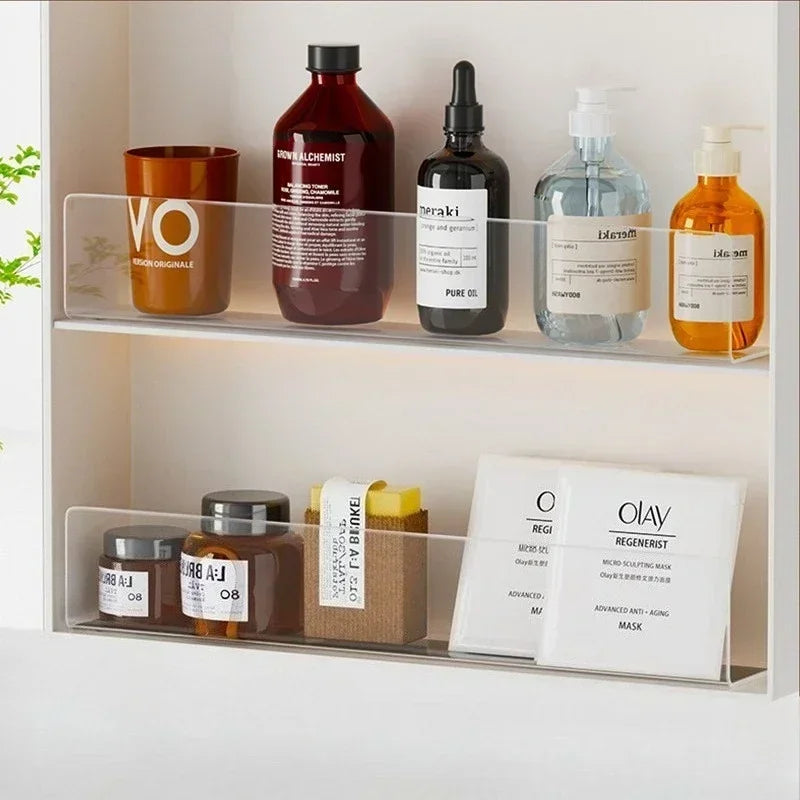 A display of various skincare products including bottles and jars on a clear acrylic shelf divider.