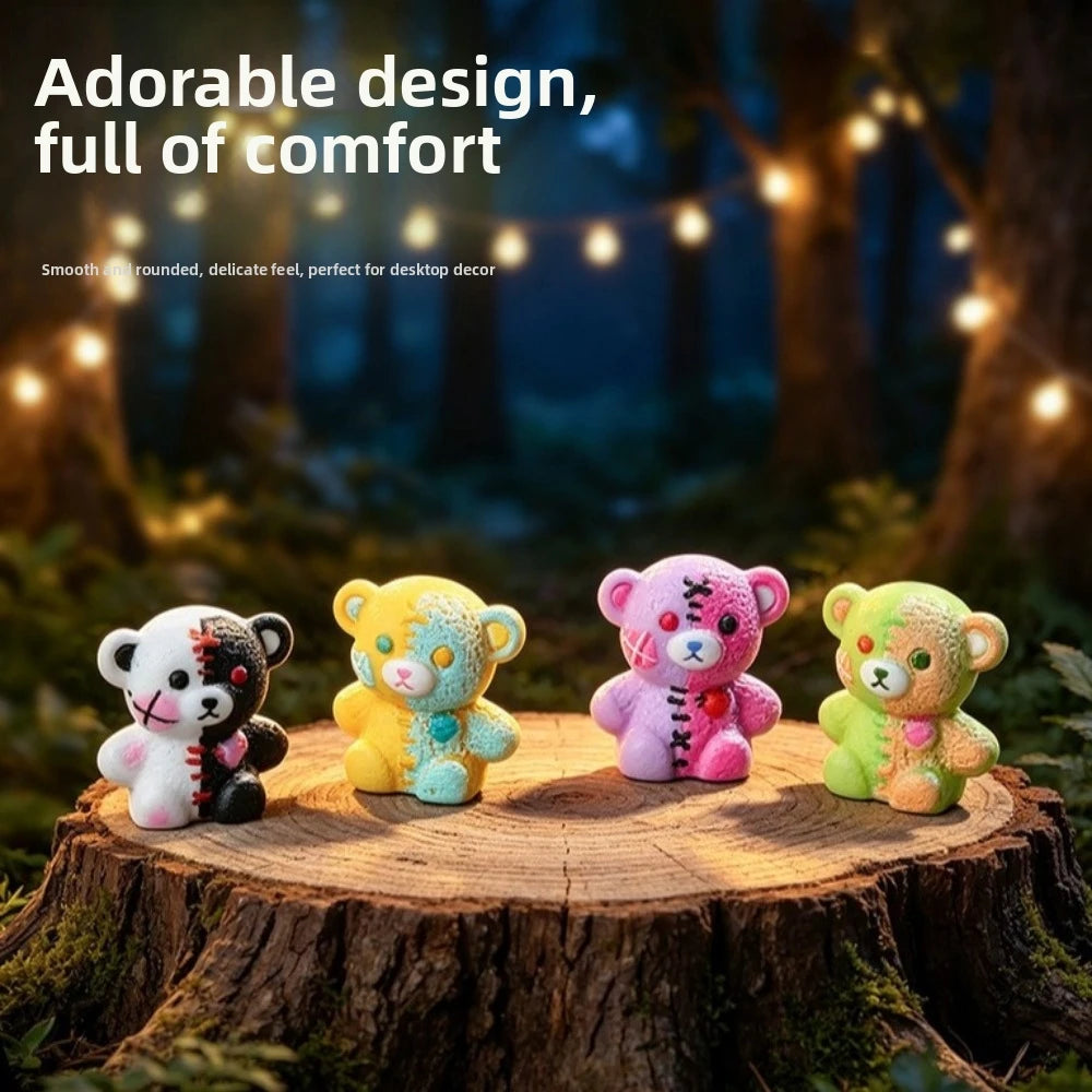 A set of four colorful resin bear figurines in white, yellow, pink, and green displayed on a wooden surface.