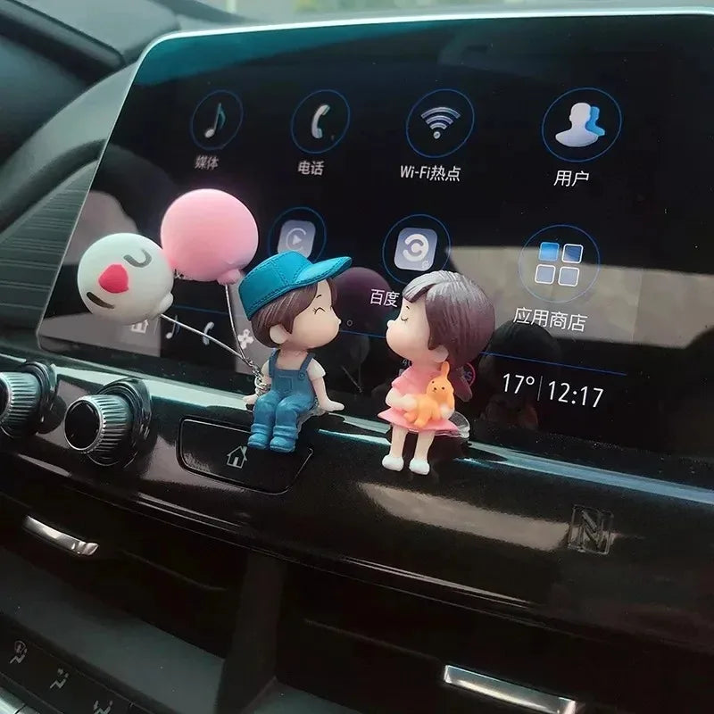 A set of cute couple balloon car ornaments displayed on a car's infotainment screen.
