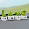 A set of four resin succulent cacti in various shapes and colors displayed on a gray surface.
