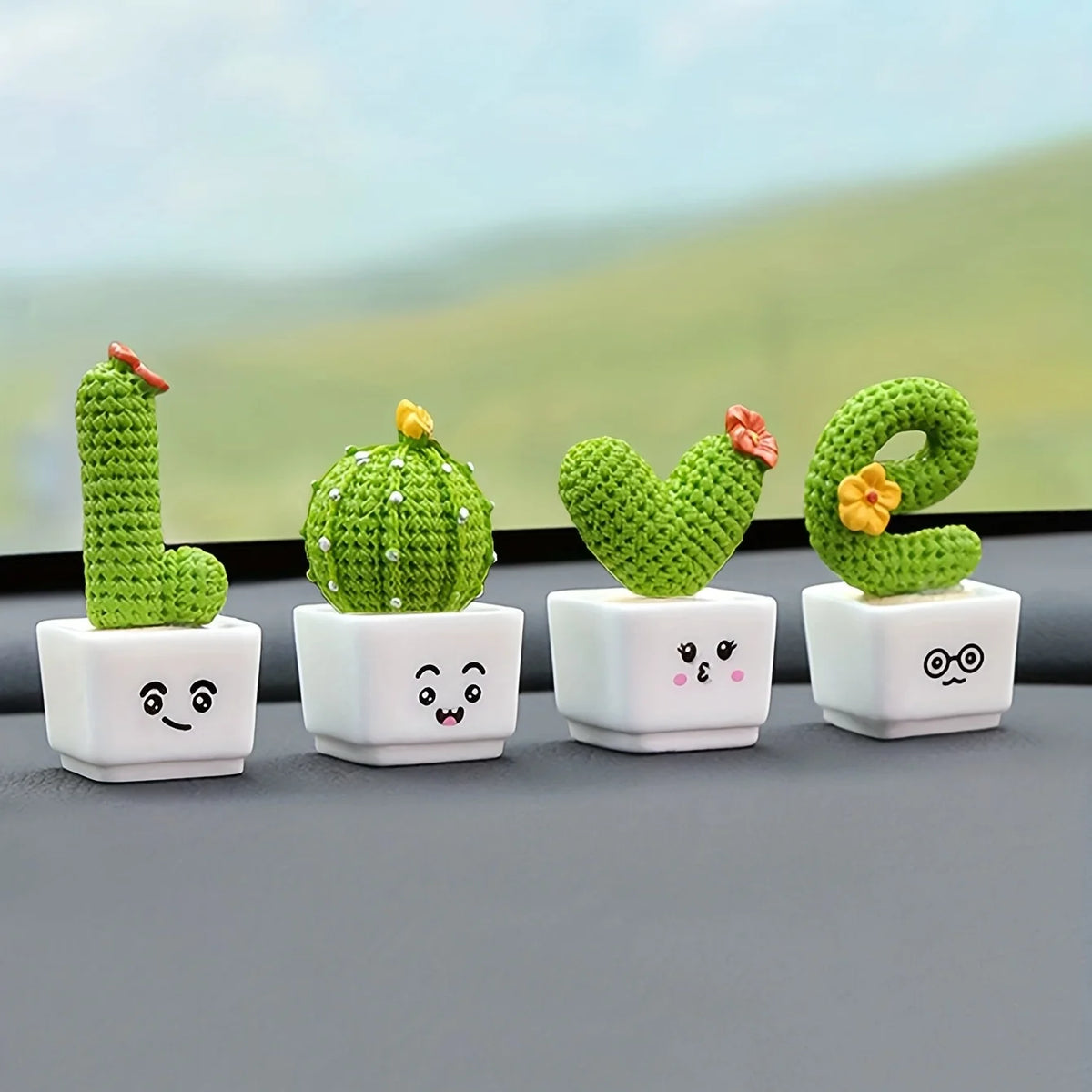 A set of four resin succulent cacti in various shapes and colors displayed on a gray surface.