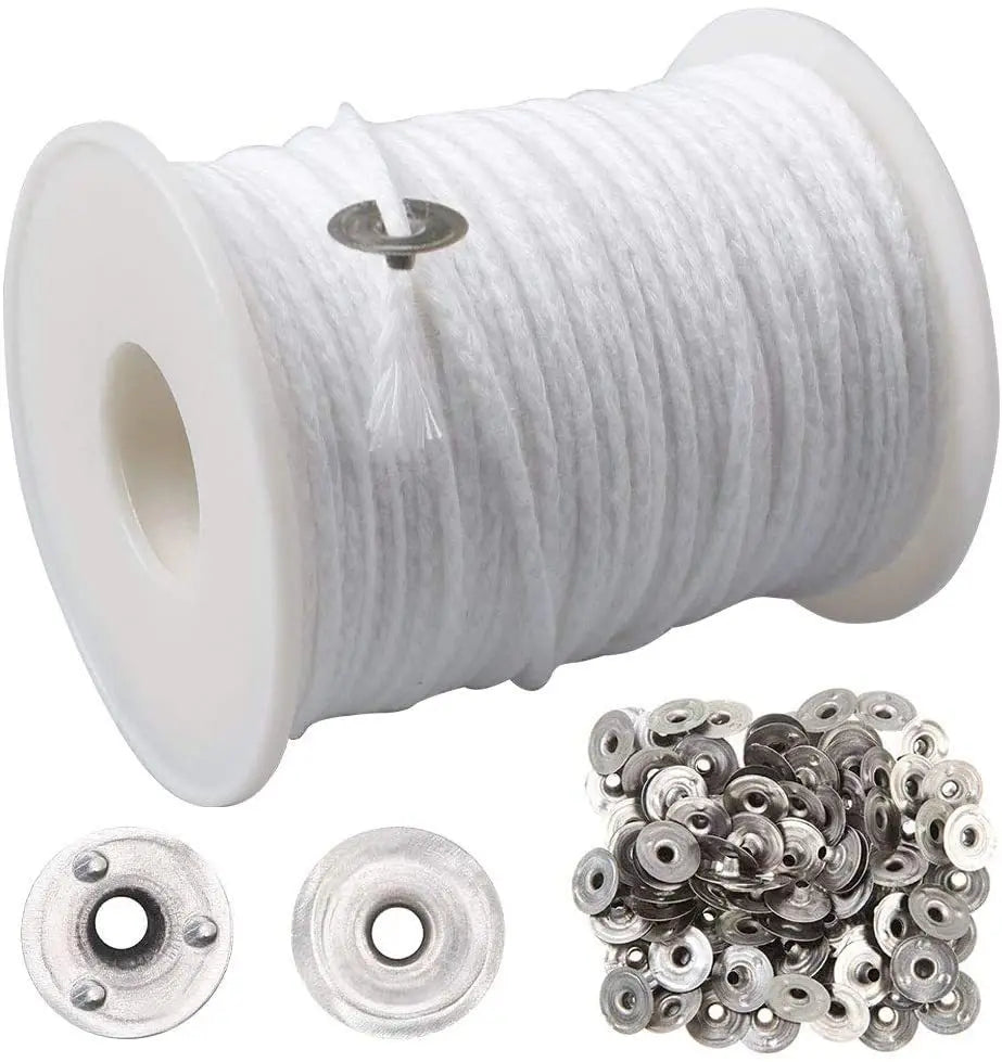 A spool of white braided cotton candle wicks and several loose metal wick holders.