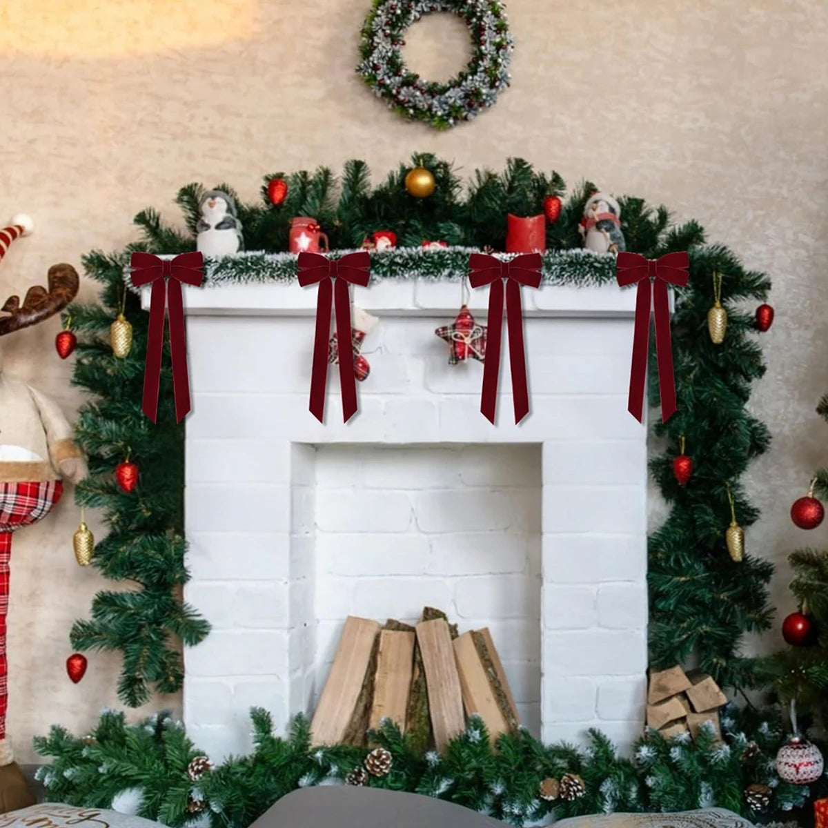 A white fireplace mantel decorated with green foliage, red bows, and ornaments for holiday Christmas decor.