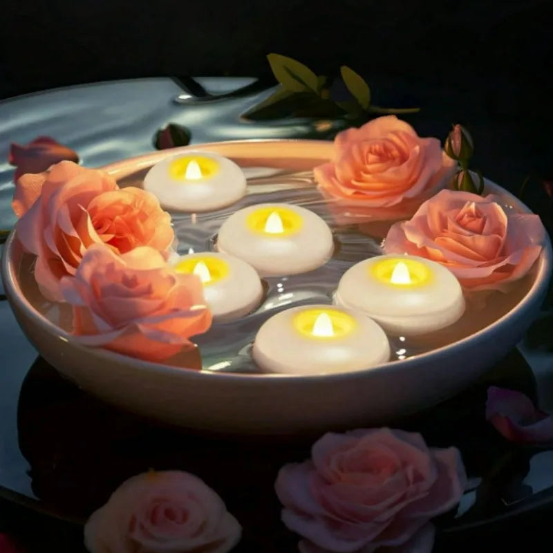 A bowl of LED floating sensor tealight candles with pink and orange roses floating on the water.