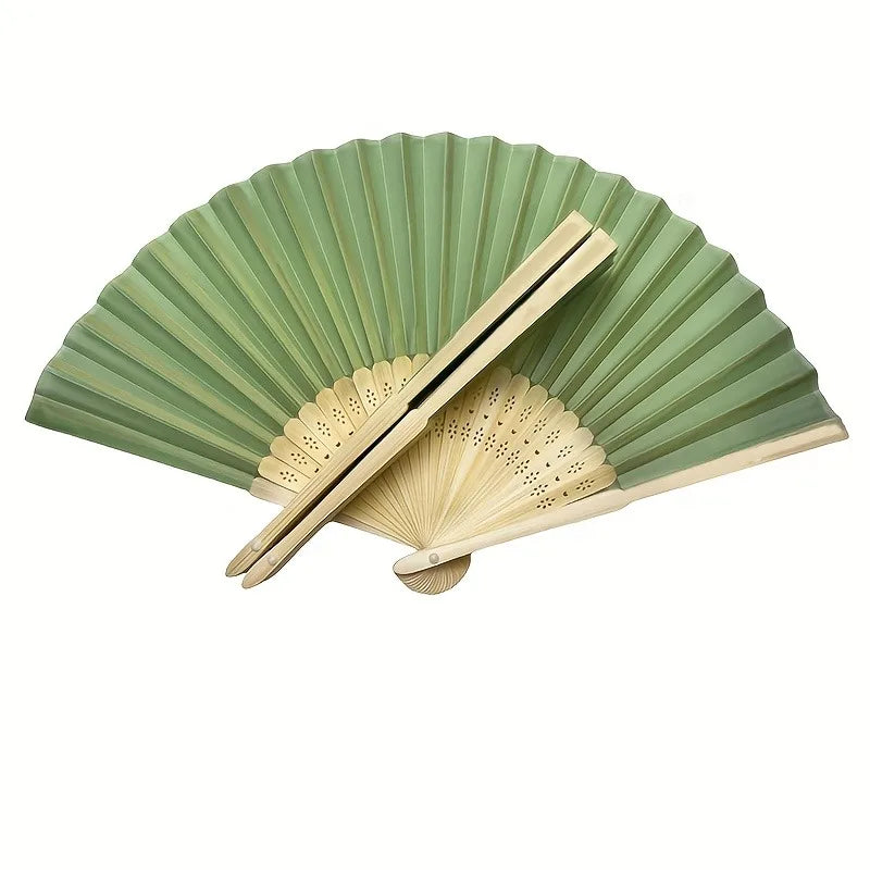 A hand-folded fan set with green pleated paper and natural wood handles.