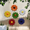 A collection of colorful iron sunflower wall art decor featuring orange, yellow, green, white, and blue flowers mounted on a 
