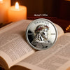 A silver faith challenge coin featuring the name Yahweh and a crown of thorns design resting on an open Bible.