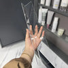 A hand holds a clear acrylic shelf divider used for cabinet and mirror storage.