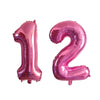 Two pink helium foil number balloons shaped like 1 and 2