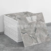 A sheet of faux marble 3D self-adhesive wall tiles showing gray and white marbled texture.