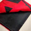 Una tapicería doblada con diseño rojo y negro, que se asemeja a la bandera ucraniana.