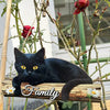 A black cat sits on a rustic wooden sign with the word Family carved into it, surrounded by green vines and red flowers.