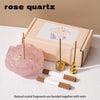 A box containing rose quartz crystal fragments and a set of wooden droppers for candle use.