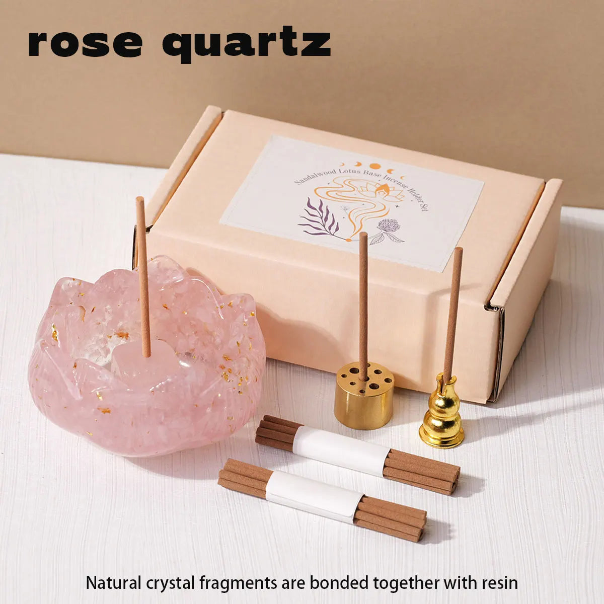 A box containing rose quartz crystal fragments and a set of wooden droppers for candle use.