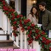 Artificial red berry holly Christmas garland decorating a white porch railing and steps.