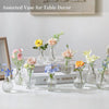Assorted glass bud vases with flowers arranged for table decor