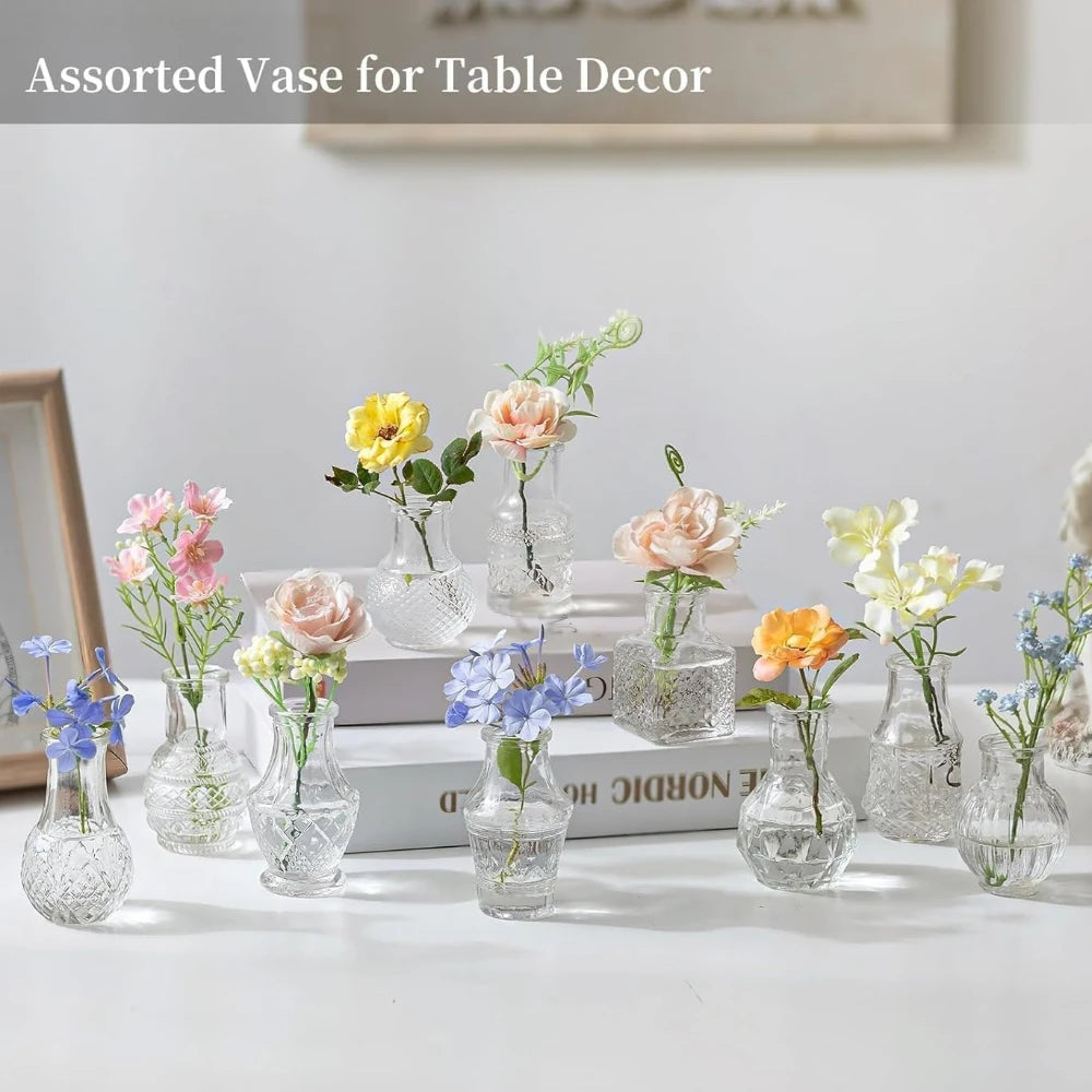 Assorted glass bud vases with flowers arranged for table decor