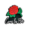 A black and red flower charm featuring a rose and green leaves, with the text Como la Flor.