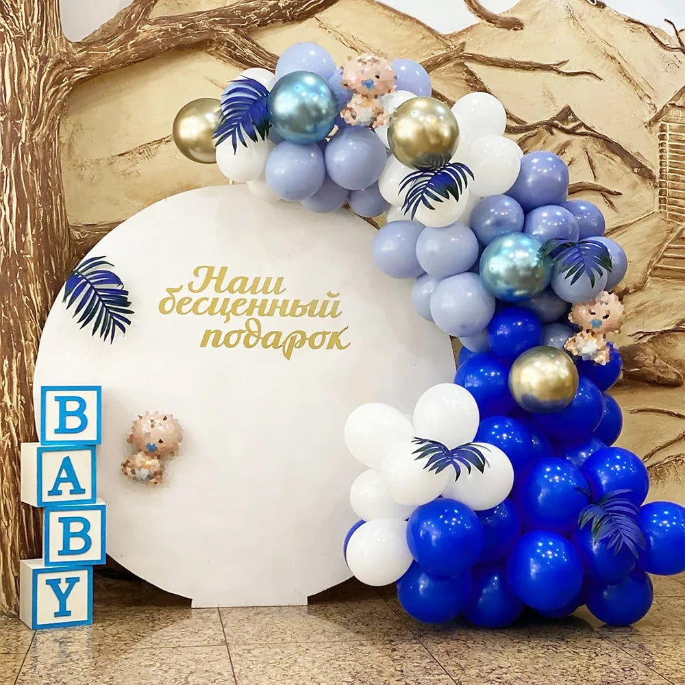 A large balloon bouquet featuring blue, white, and purple latex balloons for a baby shower or party.